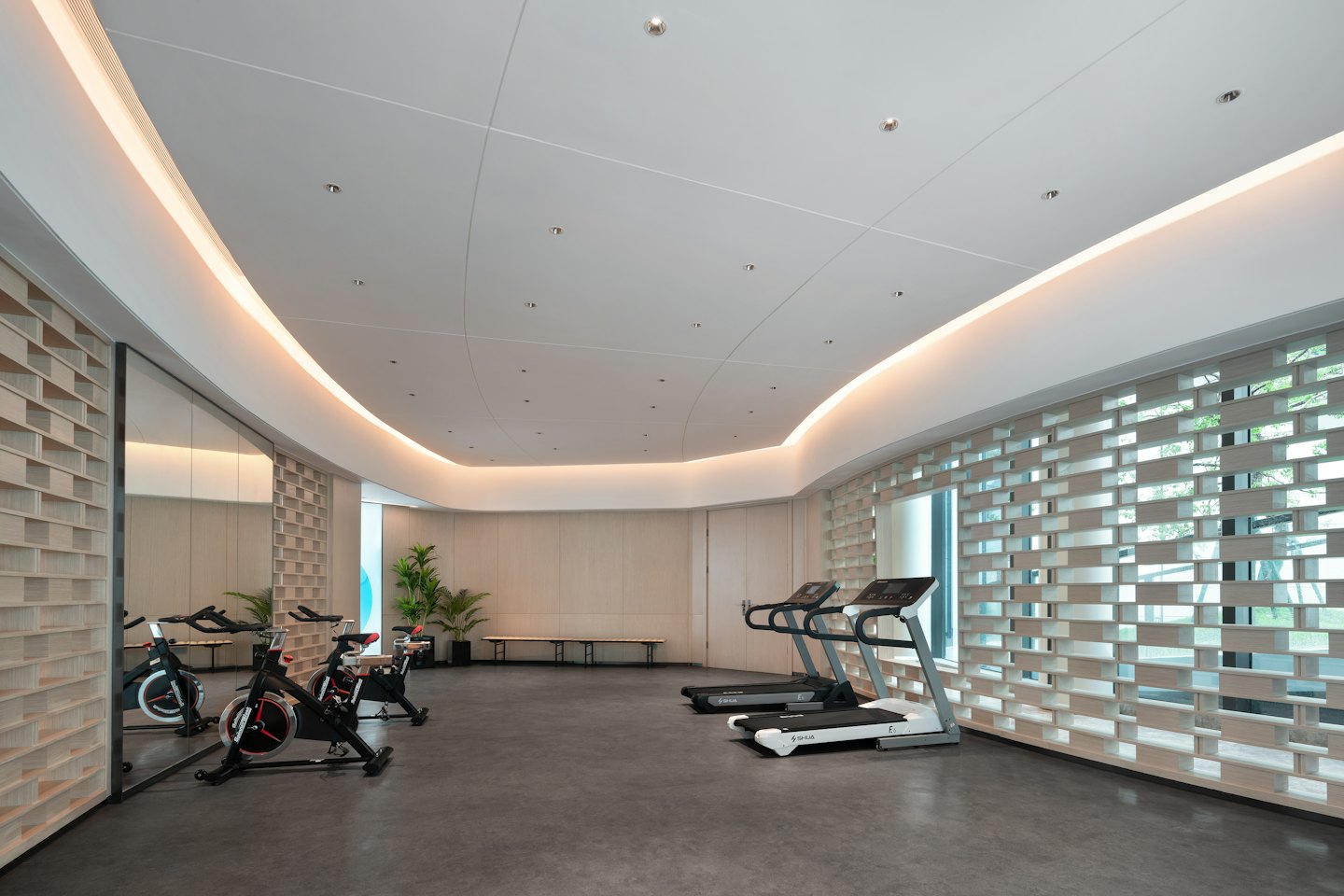 Gimnasio moderno y espacioso con máquinas de ejercicio y luz natural.