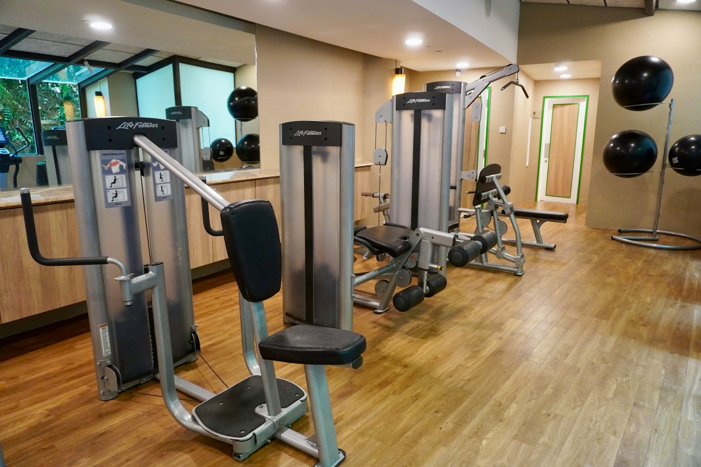 Gimnasio moderno con máquinas de fuerza y pelotas de equilibrio.